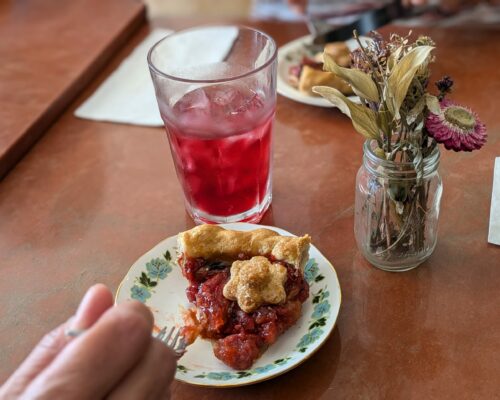 A slice of rasperry pie and a glass of juice